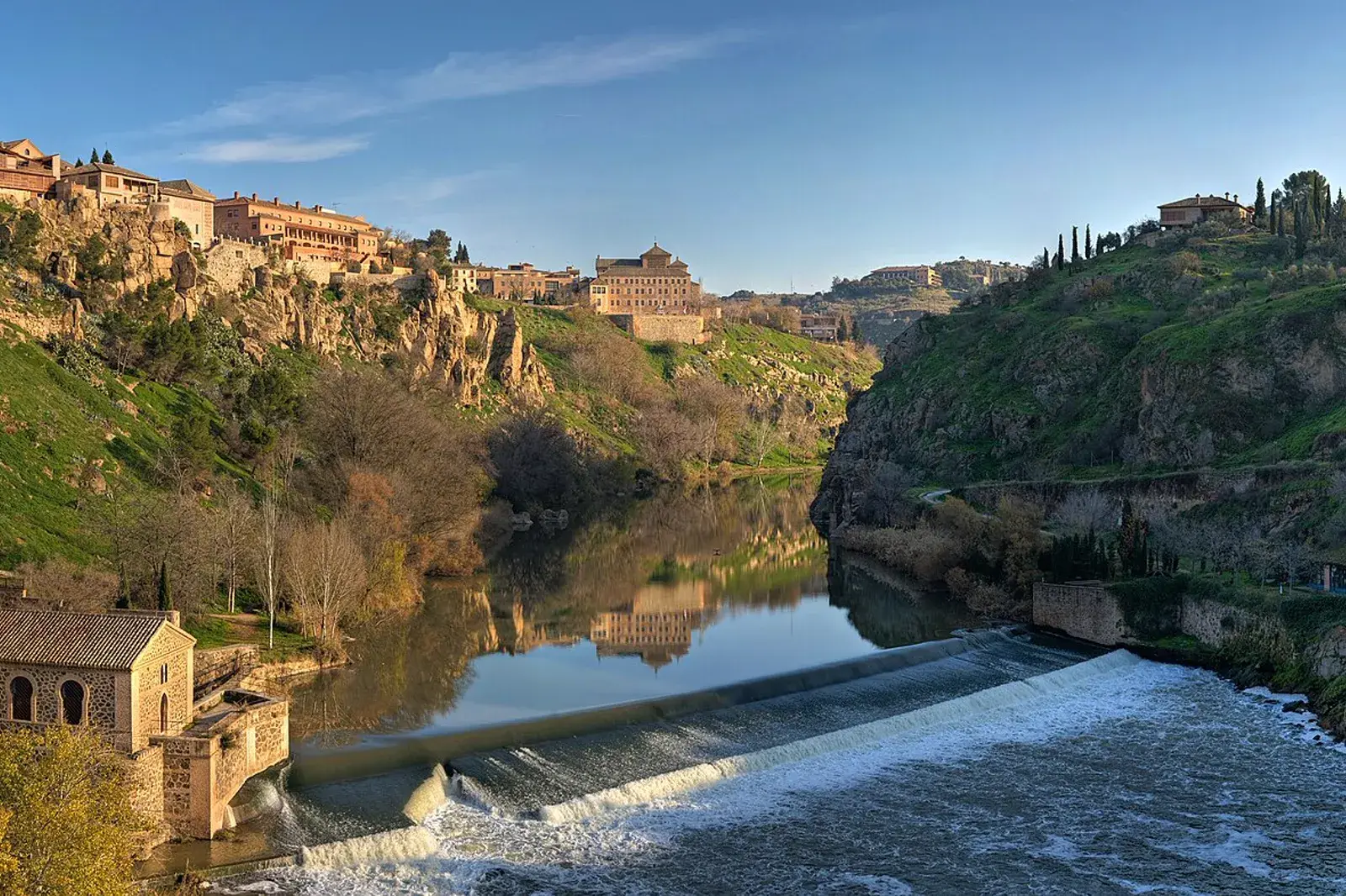 Toledo sobre el cauce del Tajo, entre laderas verdes